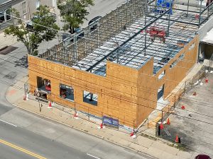 Aerial view of Teranga World Market in Hartwell, Ohio. CIncinnati commercial contractor Kiesland Development Services is building the retail space after a fire destroyed the building. The image shows an aerial view of the building under construction. The roof is not in place, allowing a view that shows scaffolding and metal framing.